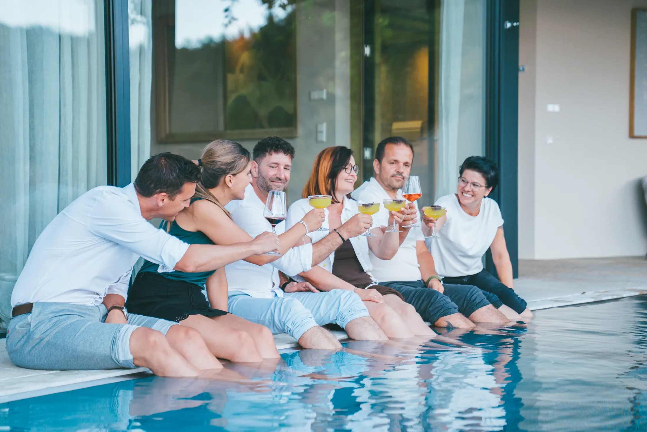 Gäste stoßen am Pool an